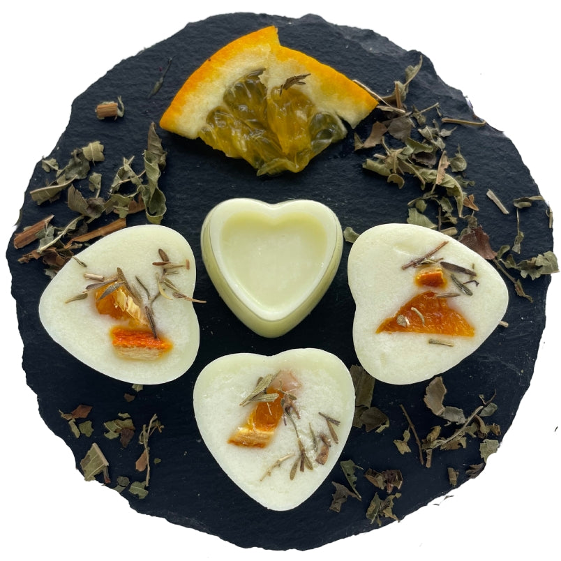 Four Florence wax melts on a circular slate with orange and thyme.