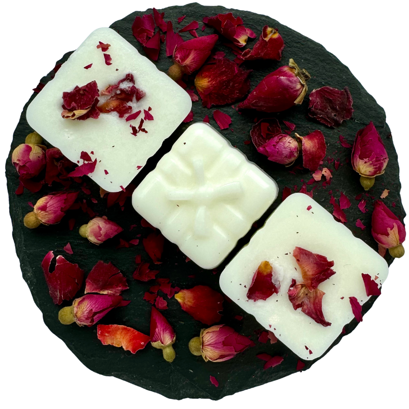 Present shaped wax melts on a circular slate with red rose buds