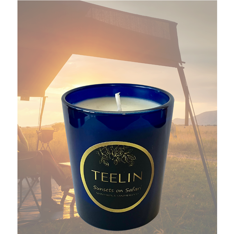 Blue sapphire candle with Teelin label superimposed on top of a image of sunset on the African savannah.